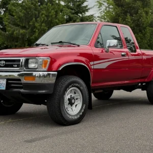 1994 Toyota Pickup XtraCab SR5 V6 4×4 5-Speed This 1994 Toyota Pickup SR5 XtraCab was initially delivered to Heartland Toyota in Bremerton, Washington, and it shows 125k miles following registration history in the state under the care of a single family. Finished in Garnet Pearl over gray cloth upholstery, the truck is powered by a 3.0-liter V6 linked to a five-speed manual transmission and a dual-range transfer case. Equipment includes 15″ styled alloy wheels, power-assisted front disc brakes, a sunroof, a sliding rear window, a bedliner, air conditioning, cruise control, power windows, and a cassette stereo. Acquired by the selling dealer in 2025, this Toyota pickup is offered at no reserve with a window sticker, manufacturer’s literature, a clean Carfax report, and a clean Washington title. No Reserve: 1994 Toyota Pickup XtraCab SR5 V6 4×4 5-Speed The truck is finished in Garnet Pearl and features a sunroof, a sliding rear window, a bedliner, and halogen headlights. Close-up photographs of the exterior finish and trim are shown in the gallery below. No Reserve: 1994 Toyota Pickup XtraCab SR5 V6 4×4 5-Speed The 15″ styled alloy wheels are mounted with 31×10.50″ Goodyear Wrangler tires. Braking is handled by power-assisted front discs and rear drums with ABS. No Reserve: 1994 Toyota Pickup XtraCab SR5 V6 4×4 5-Speed The cabin features front captain’s chairs and rear seats trimmed in gray cloth, and amenities include air conditioning, cruise control, power windows, power locks, and a cassette stereo with an in-dash CD changer. There is wear on the shift knob and a tear on the driver’s armrest. No Reserve: 1994 Toyota Pickup XtraCab SR5 V6 4×4 5-Speed Instrumentation includes a 110-mph speedometer, a tachometer, and auxiliary gauges for oil pressure, coolant temperature, voltage, and fuel level. The six-digit odometer shows 125k miles. No Reserve: 1994 Toyota Pickup XtraCab SR5 V6 4×4 5-Speed The 3.0-liter 3VZ-E V6 features fuel injection for a factory rating of 150 horsepower and 180 lb-ft of torque. The timing belt was said to have been replaced in December 2005 at 80k miles. No Reserve: 1994 Toyota Pickup XtraCab SR5 V6 4×4 5-Speed Power is sent to the rear via a five-speed manual transmission and a dual-range transmission case. No Reserve: 1994 Toyota Pickup XtraCab SR5 V6 4×4 5-Speed